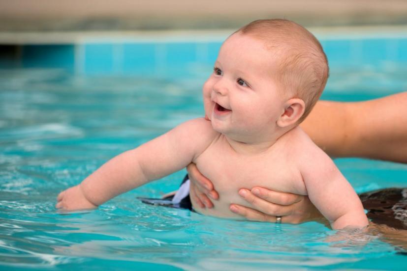 an infant held in the water